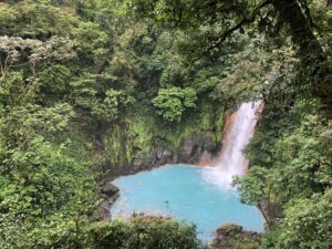 Forêt luxuriante avec en son centre une cascade à l'eau bleue turquoise | itinerares