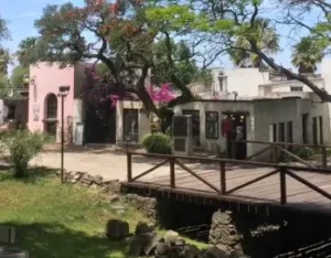 pont en bois et maisons colorées sous les arbres | itinerares