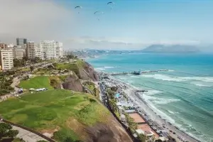 vue d'en haut de l'océan bordé par une ville et une promenade | itinerares