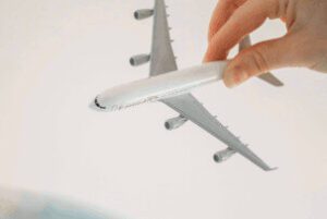 photo d'une main jouant avec un avion en plastique | itinerares