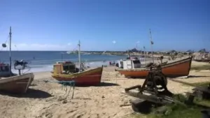 bateaux de pêcheurs sur une plage devant l'océan | itinerares