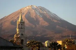 clocher d'une église devant un immense volcan | itinerares