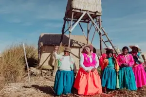 5 femmes péruviennes alignées souriant et portant des vêtements colorés | itinerares