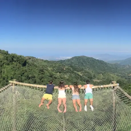 4 personnes allongés dans un hamac géant avec vue sur une montagne verte à minca | itinerares