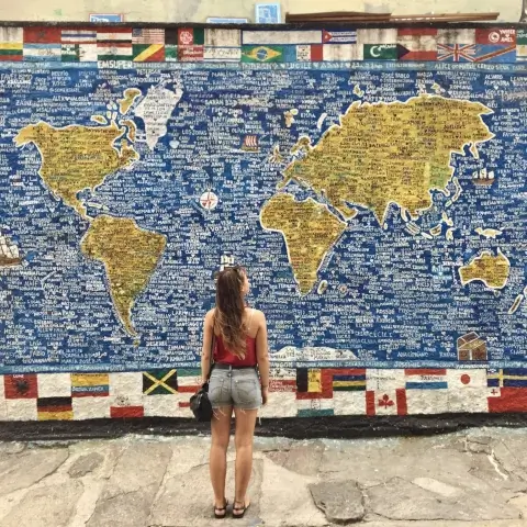 femme devant une carte du monde | itinerares