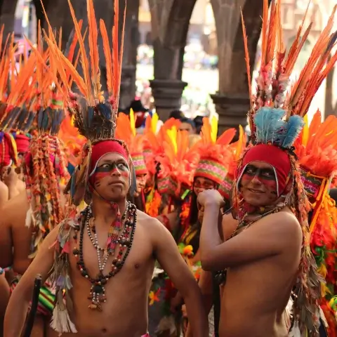 comédiens portant des plumes rouges sur la tête, maquillées et déguisées en inca pour une fête locale | itinerares